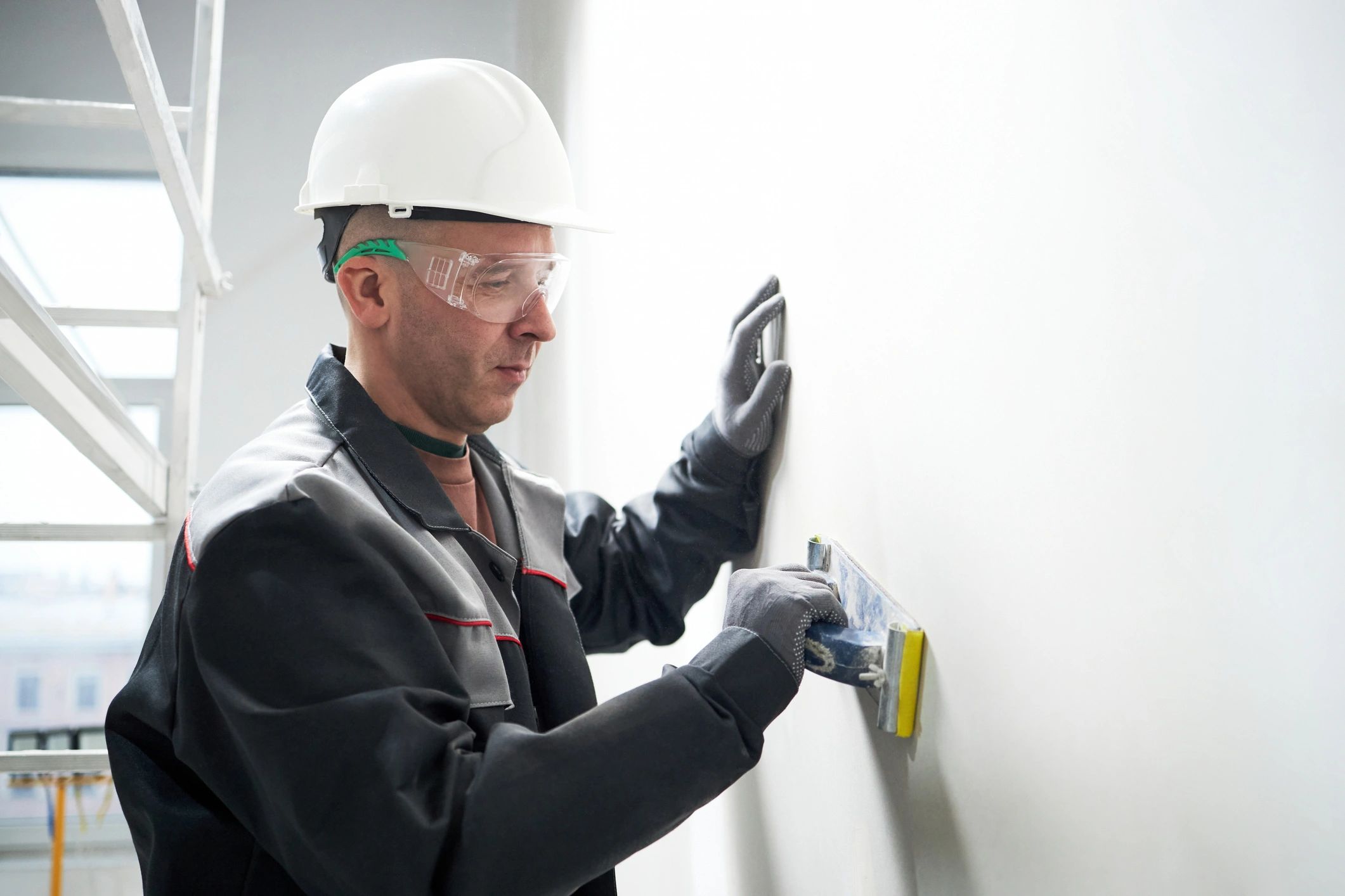 Worker repairing drywall with putty